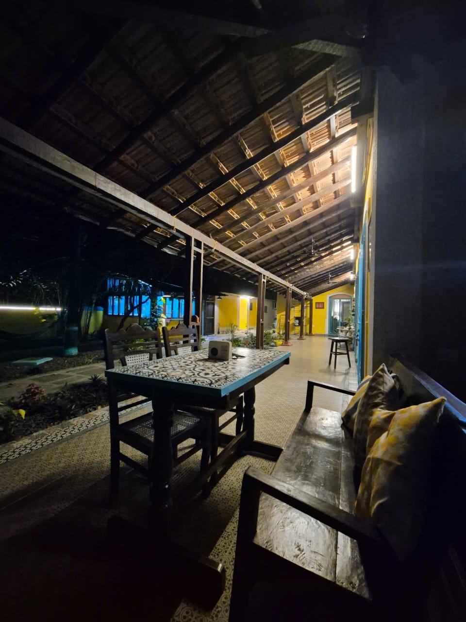 Verandah view from pool side — open-air seating area with lush garden