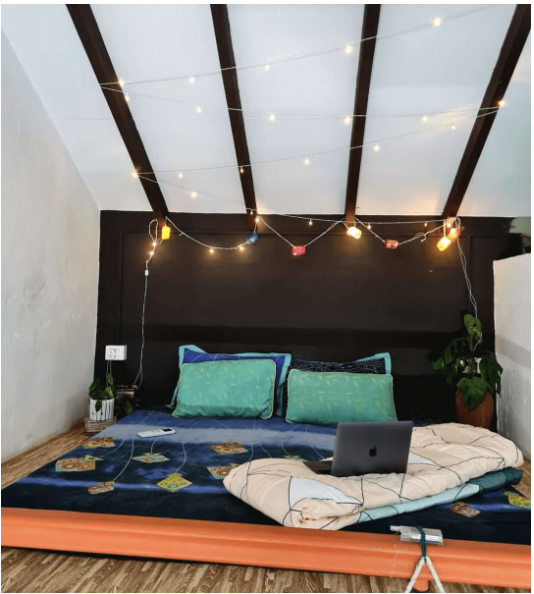 Loft Room bed view — double bed, loft-style high ceilings, warm ambient light